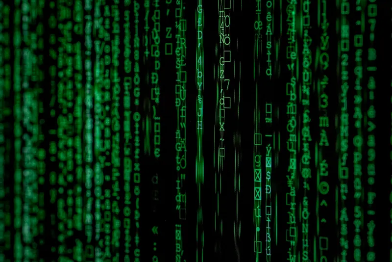 Green computer code reflected on a dark screen