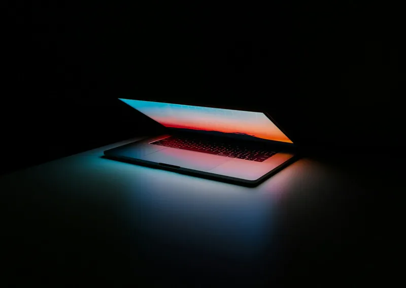 A laptop glowing in a dark room