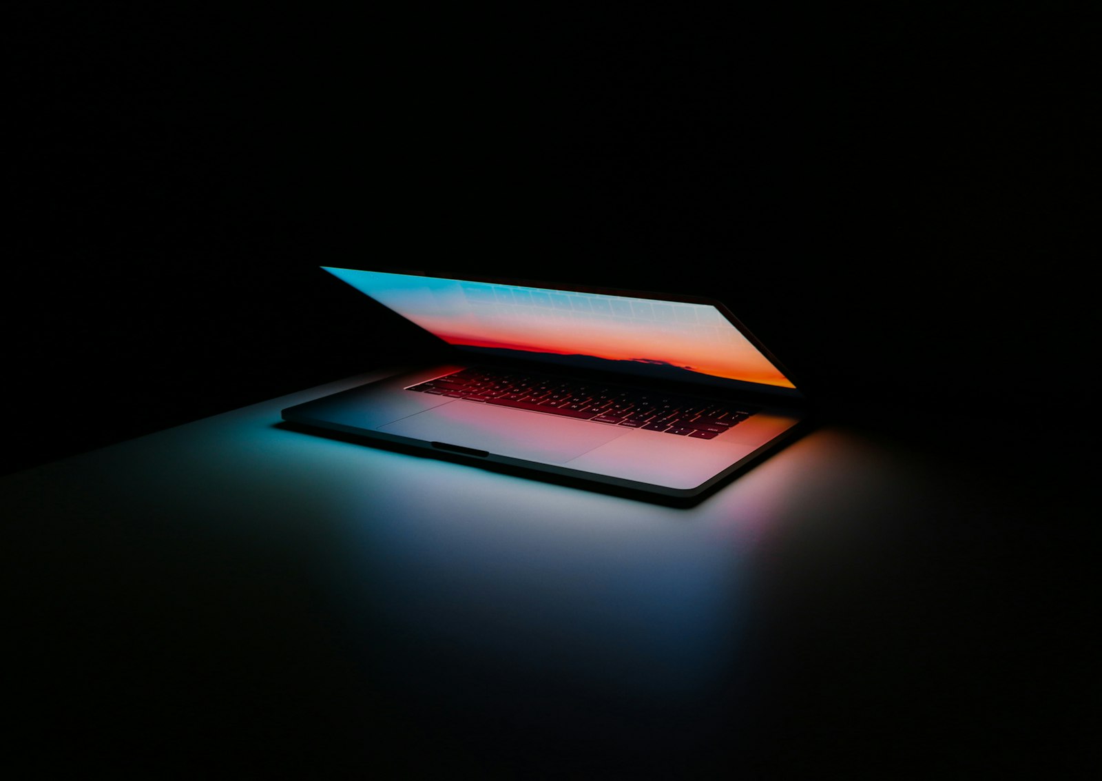 A laptop glowing in a dark room