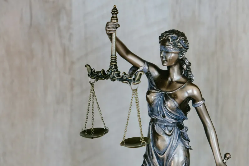 A wooden gavel beside justice scales