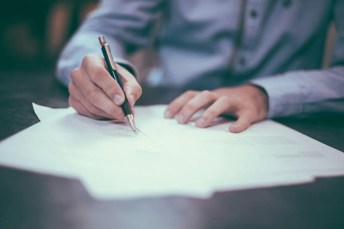 Printed documents on a desk with a pen
