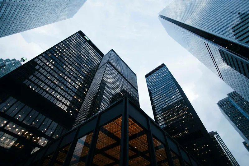 Looking up at glass skyscrapers in a financial district