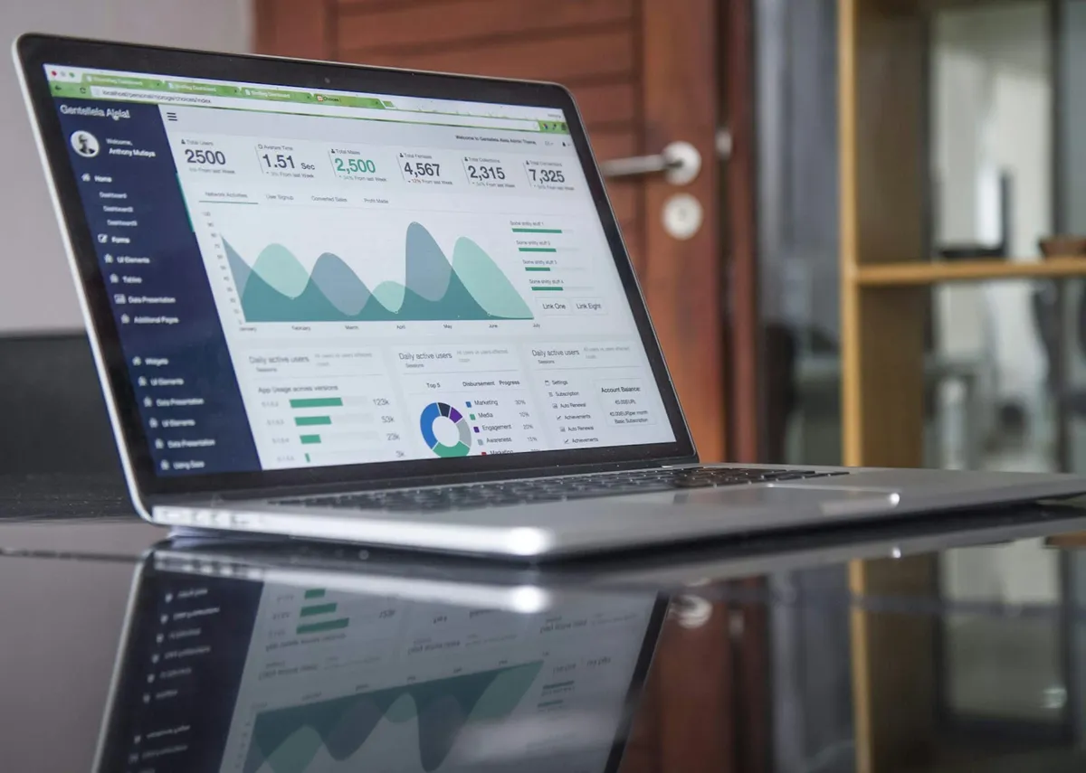 Laptop showing colourful analytics charts on a wooden table
