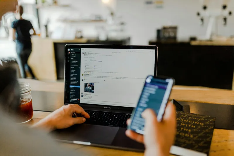 Hands typing on a laptop with a security graphic overlay