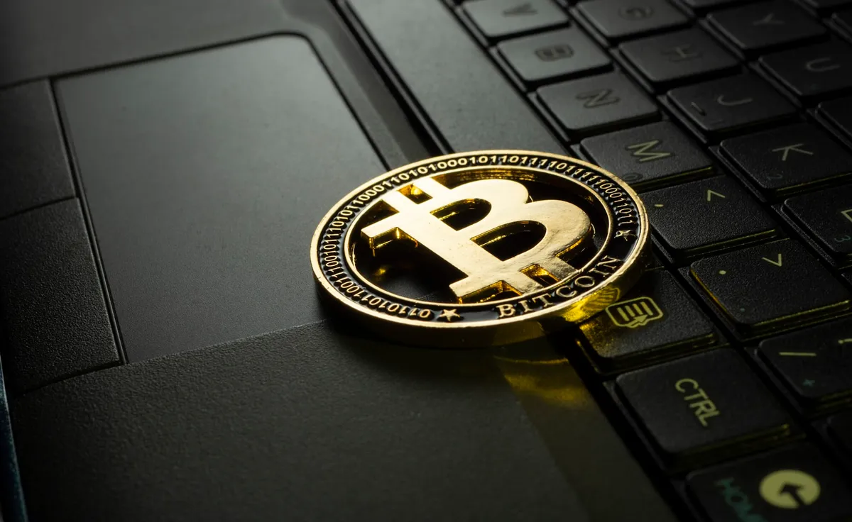 Close-up of a physical bitcoin coin showing the Bitcoin symbol